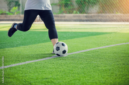 women soccer player put black sport shoes and run for shoot ball to goal on artificial turf