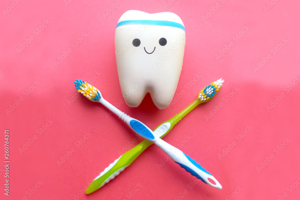 Sign of purity and health of teeth symbol from brushes and a smile of a tooth on a red background Sign of purity and health of teeth symbol from brushes and a smile of a tooth on a red background