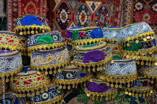 National colored headwear with national patterns of Buta on the background of carpets with national paintings. 