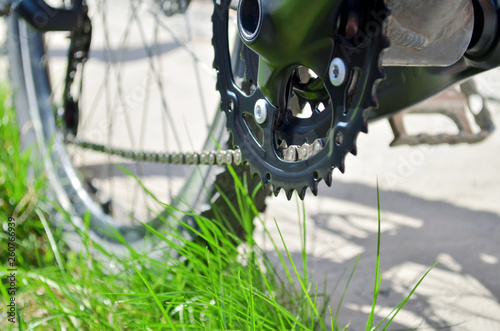 New transmission on an old grey bicycle that stands on the grass, bottom view of the rear wheel photo