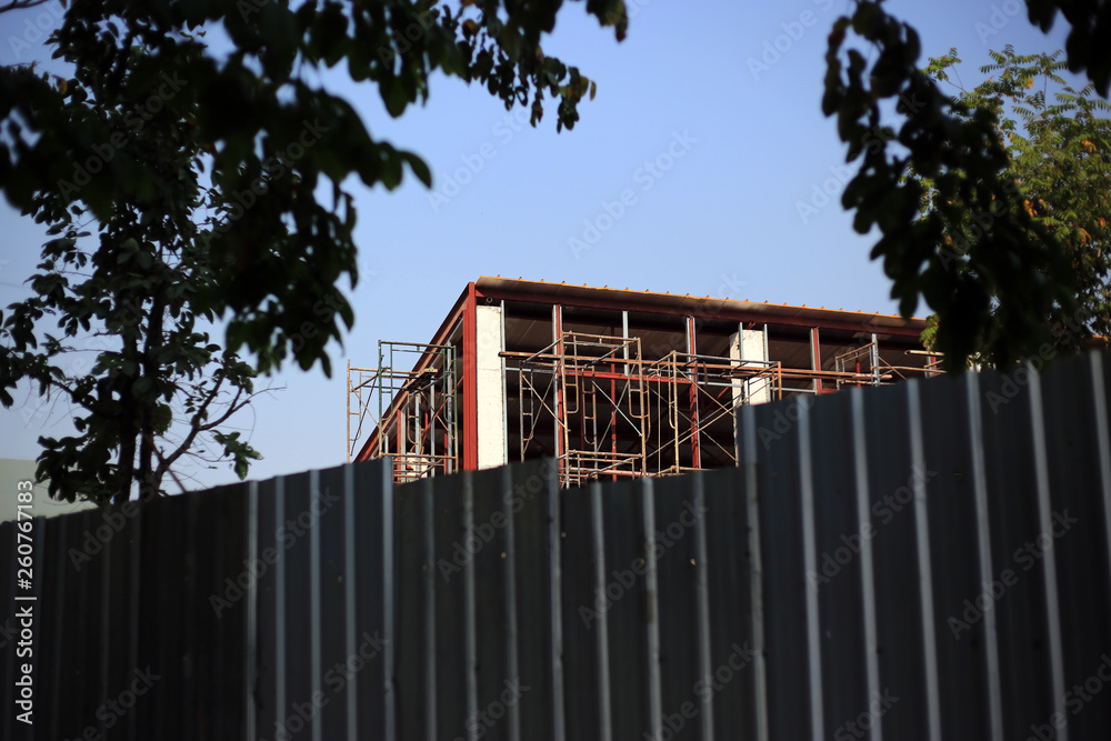 Fototapeta premium Structure building and scraffoldings in site construction with metal wall for safety work.