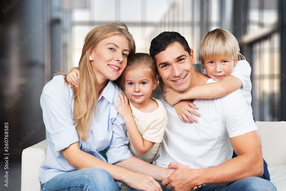 Beautiful smiling family sitting at sofa at home