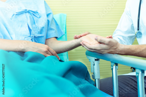 Closed up of Hands of doctor man reassuring woman patient on bed in  hospital .Professional medical doctor comforting patient at consulting room. Medical ethics and trust healthcare concept © kittipong