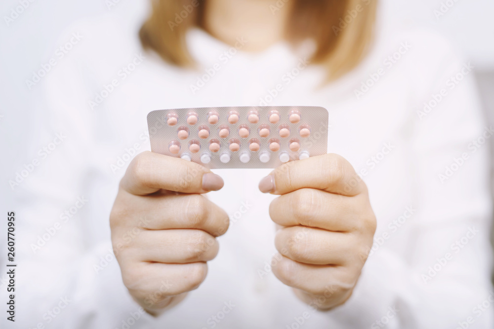 Woman hands opening birth control pills in hand. eating Contraceptive pill. Contraception reduces childbirth and pregnancy concept. - obrazy, fototapety, plakaty 