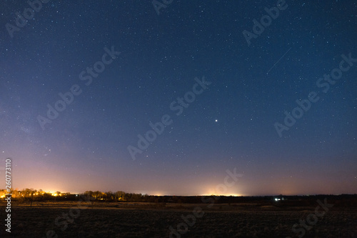 Starry sky over the dark field late at night