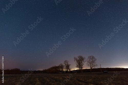 Starry sky over the dark field late at night