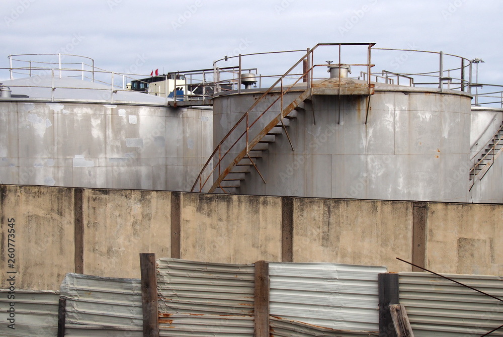 custom made wallpaper toronto digitalold metal industrial storage tanks with rusty inspection ladders and valves surrounded by a corrugated steel fence and wall