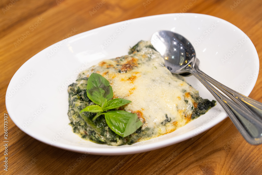 Close up of spinach with cheese on wooden table. Close up of spinach with cheese on wooden table.