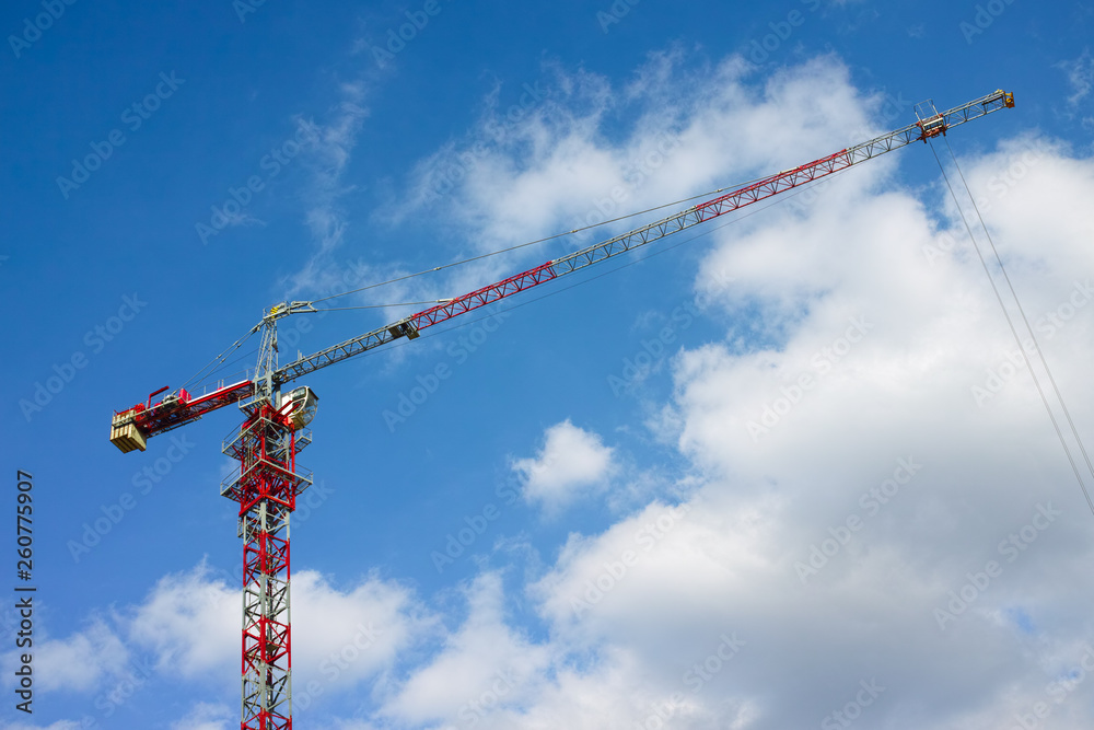 Construction crane against blue cloudy sky Construction crane against blue cloudy sky