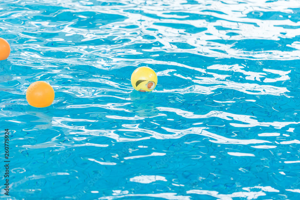 Orange and Yellow Inflatable ball Floating on water surface