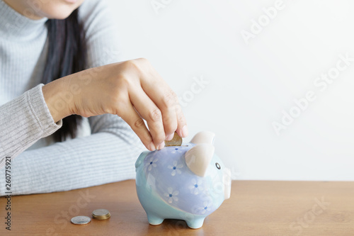 woman hands putting coins in piggy save money for investment. Concept of saving money.