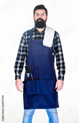 Outdoor cooking. Bearded man wearing apron with grill gripper tools in pockets. Hipster with metal utensils for barbecue grill. Grill cook. Preparing food on grill using a barbecue set © be free