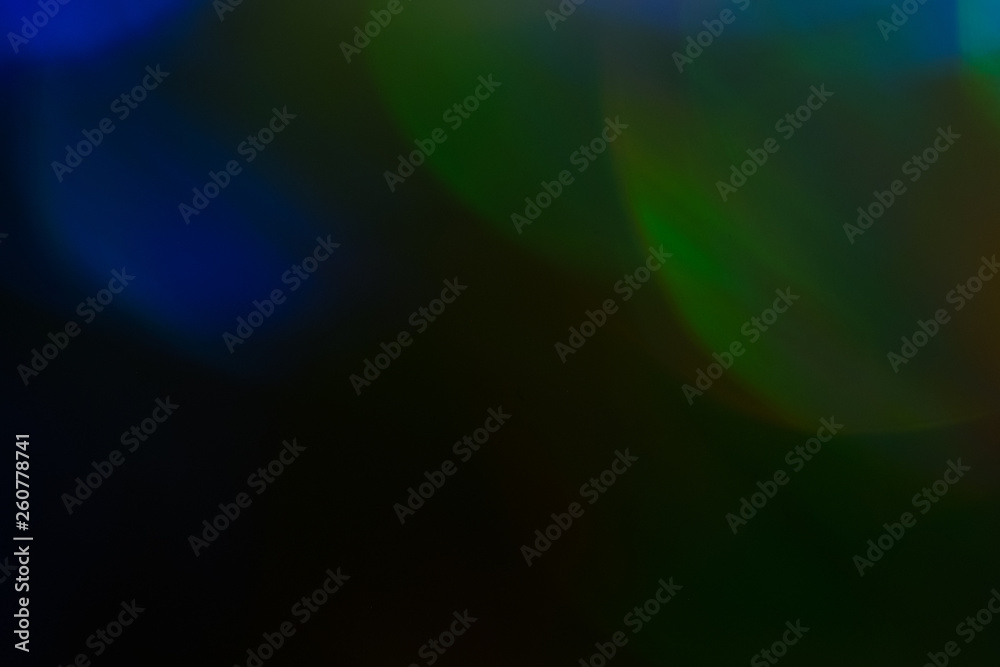 Fototapeta premium Blurred lens flare lights. Defocused dark abstract background. Glowing effect.