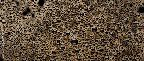 Panoramic shot of black coffee texture with bubbles