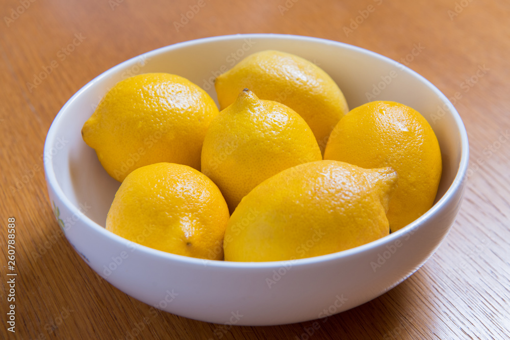 Fresh yellow lemons on a wooden background.