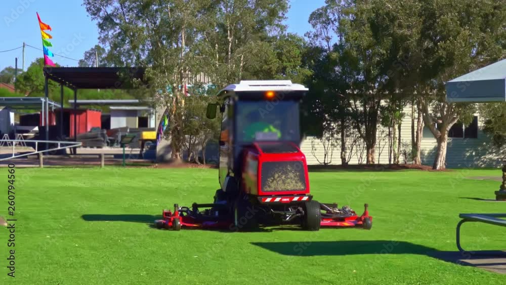 Slow motion of commercial ride-on lawnmower in the yard Slow motion of commercial ride-on lawnmower in the yard