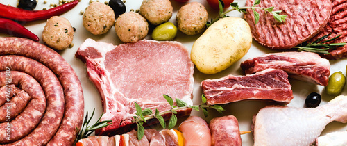 different types of raw meat: chicken thighs, pork and beef burgers, ribs and kebabs, turkey meatballs, ready to be cooked with potatoes, hot pepper, olives and black olives and . Meat Food Background