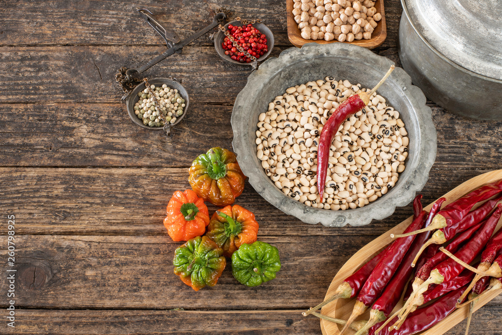 Legumes in the bowl and in the copper cookware on the rustic wooden table