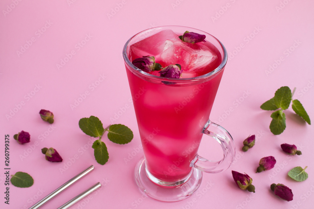 Cold lemonade or tea with pink roses on the pink background Cold lemonade or tea with pink roses on the pink background