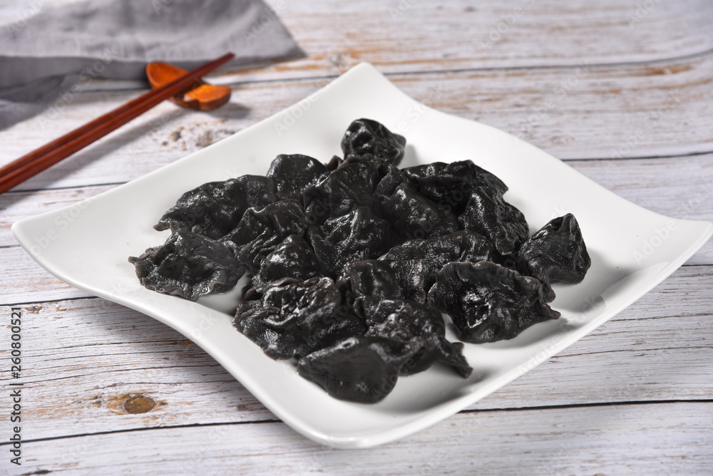 black tea in a bowl on wooden background black tea in a bowl on wooden background
