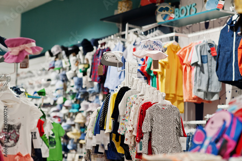 Children's bright clothes hang on the display in the baby clothing store. © AS Photo Family