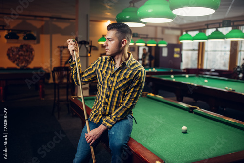 Konstfotografi Male billiard player with cue poses at the table