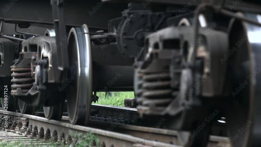 Wheels of the train moving along the rails closeup. Slow motion