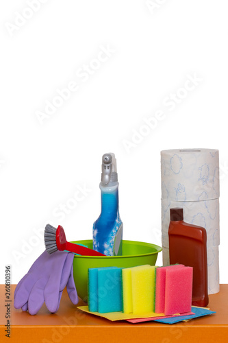 Spring cleaning background. Close-up of house cleaning products and cleaning supplies on orange wooden table isolated on a white background. Household chore concept. Macro.