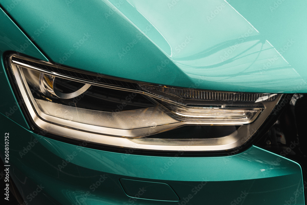 Closeup headlights of a modern Mint color car. Detail on the front light of a car. Modern and expensive car concept. Neo Mint color of the year 2020