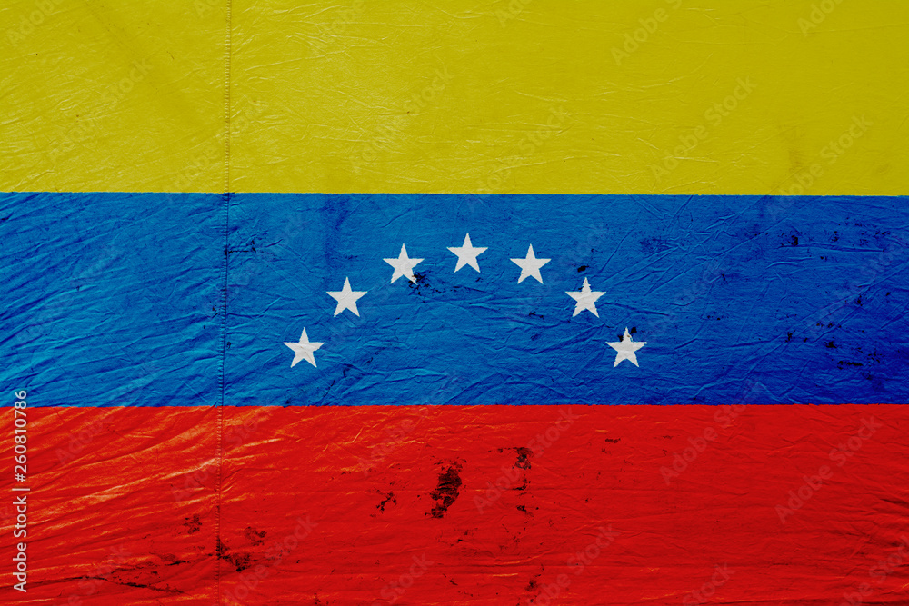 Image of the flag of Venezuela on the dirty, bright canvas tent wall