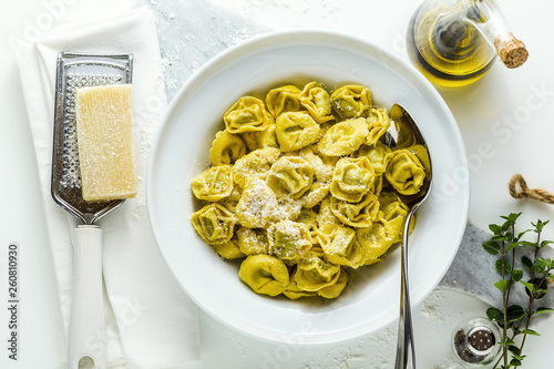 plate of italian cooked ravioli tortellini with parmesan cheese on the table. healthy Mediterranean food