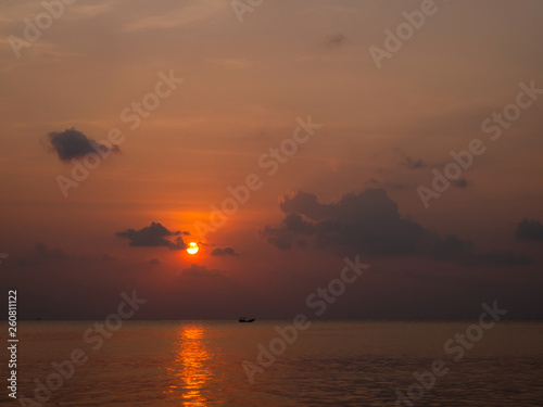 Silhouette of a boat on the background of the setting sun with clouds. Koh Phangan Thailand