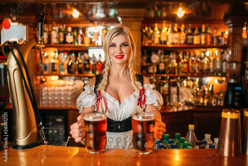 Waitress holds two mugs of beer at the counter