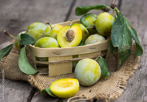 Plum harvest. Plums in the basket on the wooden old table