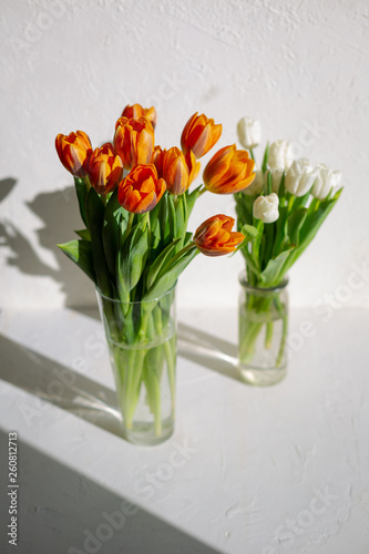 Two vases with spring orange and white tulips