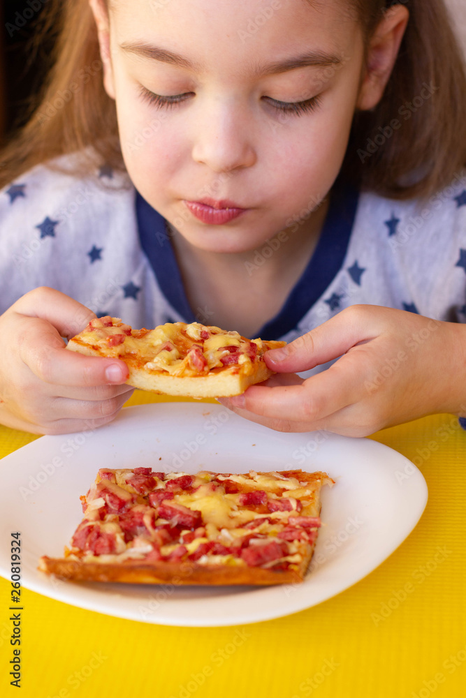 Little girl eating pizza
