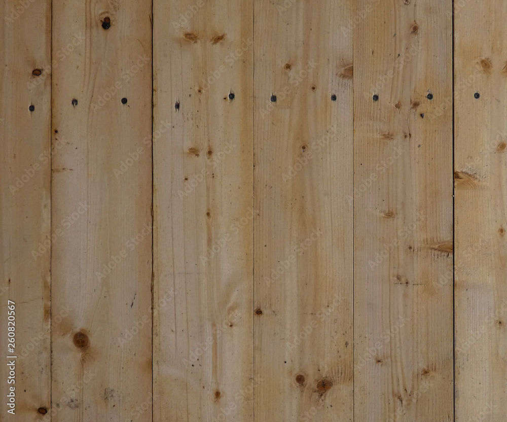 New wooden wall. Big fresh boards with knots. Natural background, wood texture. Vertical structure.