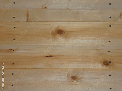 New wooden wall. Big fresh boards with knots. Natural background, wood texture. Horizontal structure.
