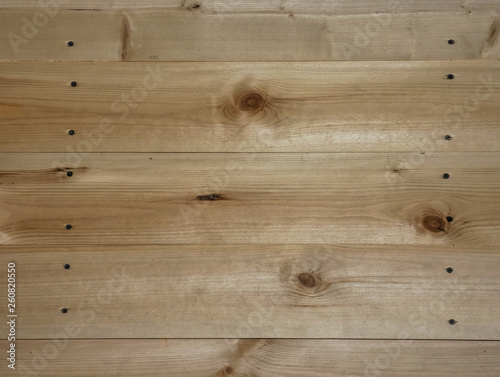 New wooden wall. Big fresh boards with knots. Natural background, wood texture. Horizontal structure.