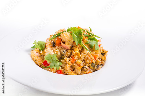 seafood risotto with sesame in a white plate