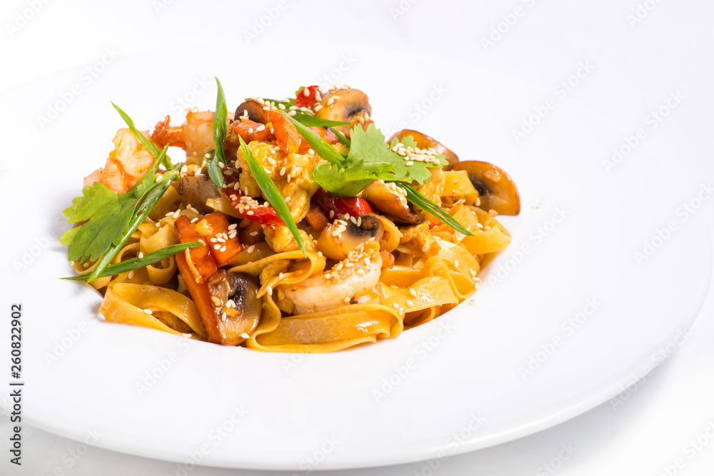 seafood and sesame pasta in a white plate