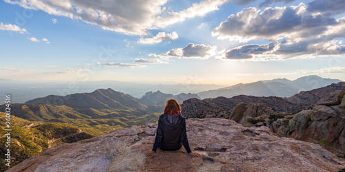 A woman staring down from the top of Mount Lemmon in Arizona while the sun starts to set. photo
