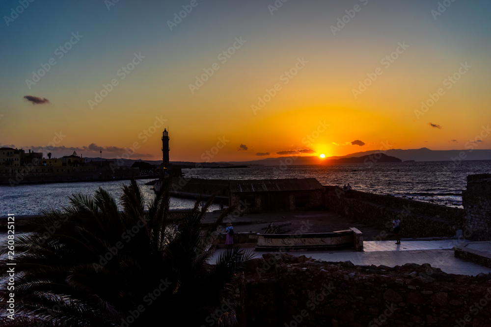 Panorama venetian harbour waterfront and Lighthouse in old harbour of Chania at sunset, Crete, Greece