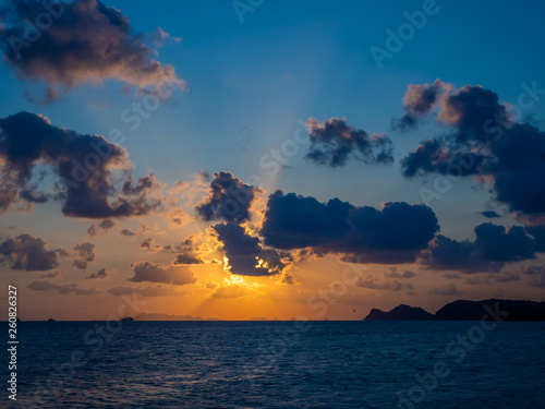 Silhouette of a ferry in the rays of the setting sun with clouds. Koh Phangan Thailand
