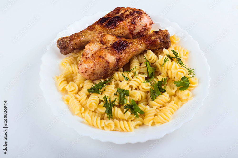 Grilled chicken drumstick and pasta on white plate, white background