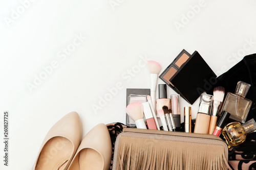 Makeup bag with cosmetic beauty products. Beauty and Fashion concept. Shoes, makeup products and handbag on white background