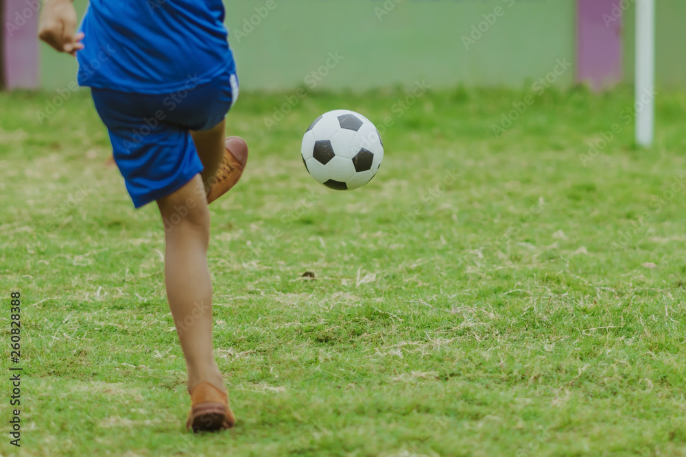 Asian boys practice kicking the ball to score goals in the public football field. Asian boys practice kicking the ball to score goals in the public football field.
