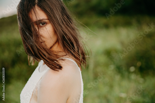 Принти на полотні Happy woman with windy messy hair backlit by sun selective focus colorized image