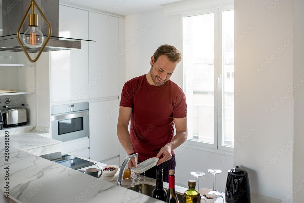 Man washing dishes in a modern kitchen Man washing dishes in a modern kitchen