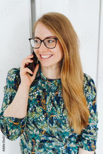 Happy young woman chatting on her mobile phone